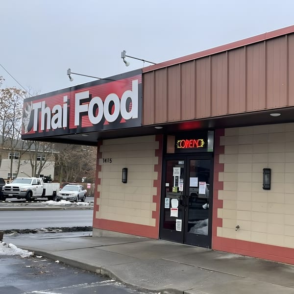 Exterior of Our Thai House, a Thai restaurant, with a large "Thai Food" sign and an "OPEN" neon sign.