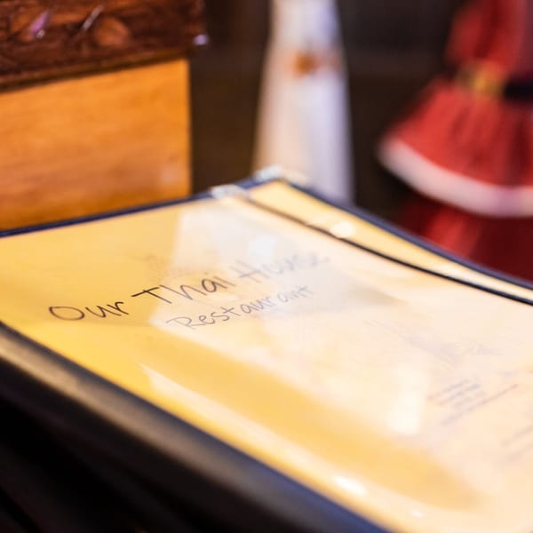 A close-up of the "Our Thai House Restaurant" menu on a table.