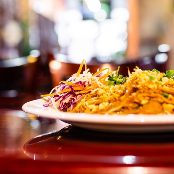 Our Thai House Pad Thai, garnished with shredded cabbage, carrots, and crushed peanuts.