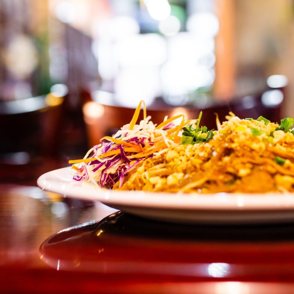 Our Thai House Pad Thai, garnished with shredded cabbage, carrots, and crushed peanuts.