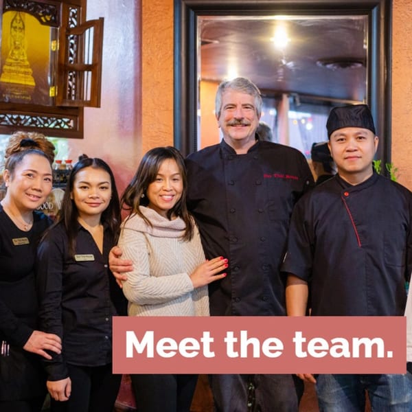Our Thai House team, including the chef, smiling in the restaurant dining area.