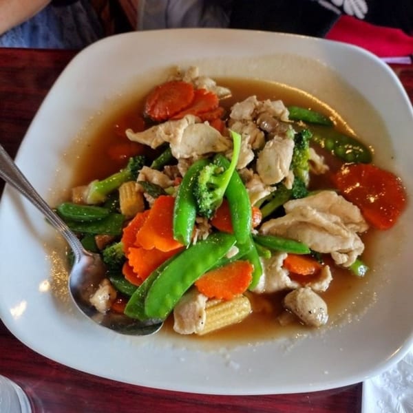 Our Thai House stir-fry with chicken, broccoli, carrots, snow peas, and baby corn in sauce.
